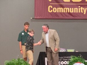 Greylan shaking hands with Dr. Mike Yoder.