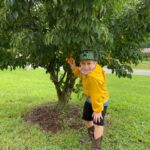 young person beside a tree