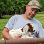 farmer holding baby goat