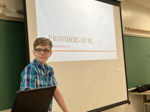 A kid stands to give a presentation.