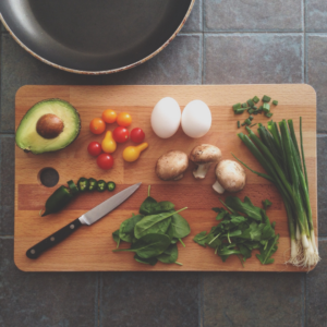 wooden cutting board with vegetables and knife