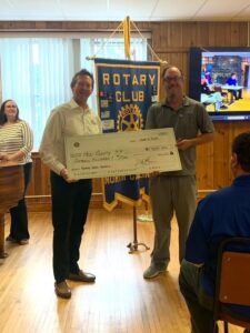 Two men hold a check, signifying a donation to the county center.